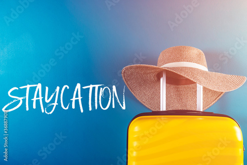 Staycation word with suitcase photo