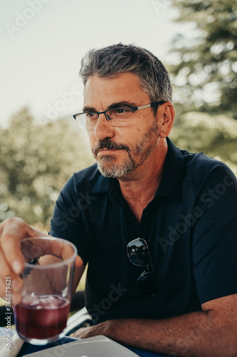 Adult man enjoying red summer wine.