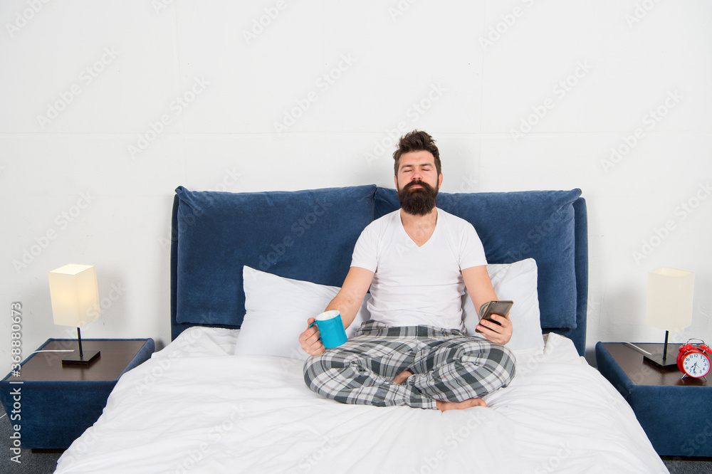 Fototapeta premium Man pajamas sit bed bedroom morning meditation, yoga exercises concept