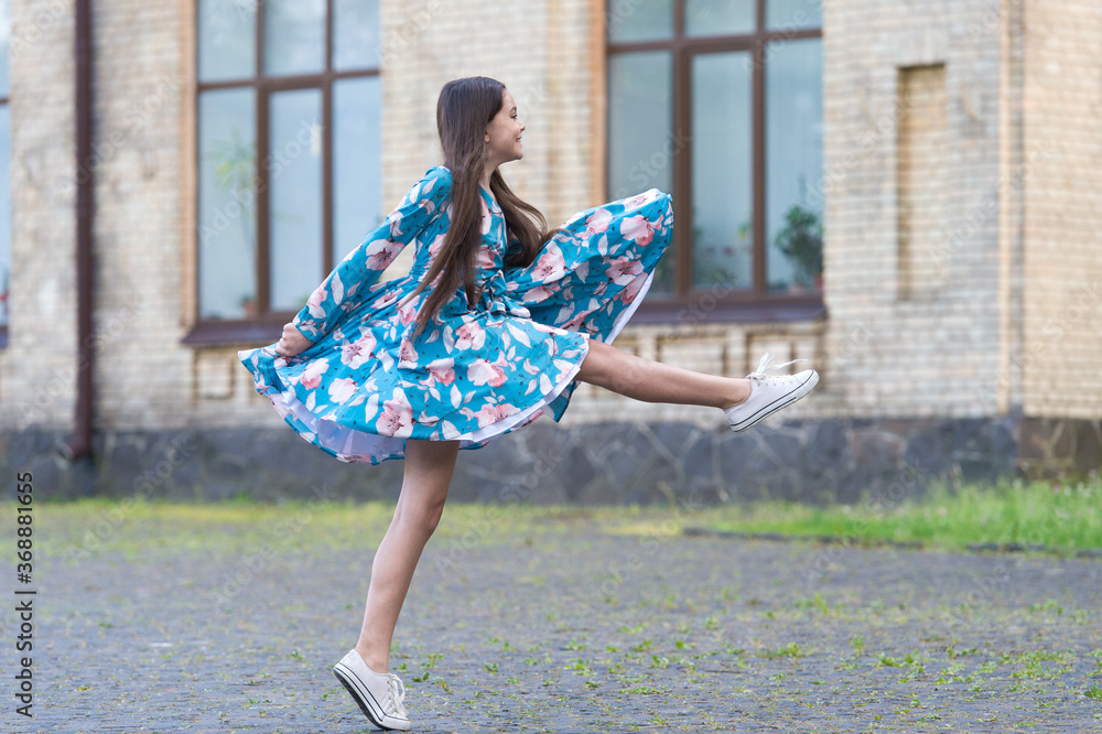 Girl summer dress flutters in motion urban background, against wind concept