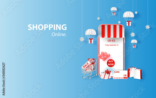 Shopping Online on smartphone or Mobile Application Concept idea Marketing and Digital marketing. Merry Christmas background Horizontal view with gift box and parachute of content sale in holiday