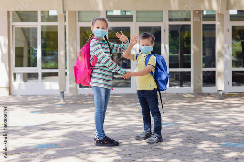 Wallpaper Mural Back to school. Brother and sister, girl and boy with school backpacks go to study after a pandemic, quarantine or coronavirus. First school day. Torontodigital.ca