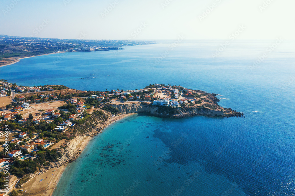Cyprus landscape aerial view of yellow stone coast with villas and blue mediterranean sea.