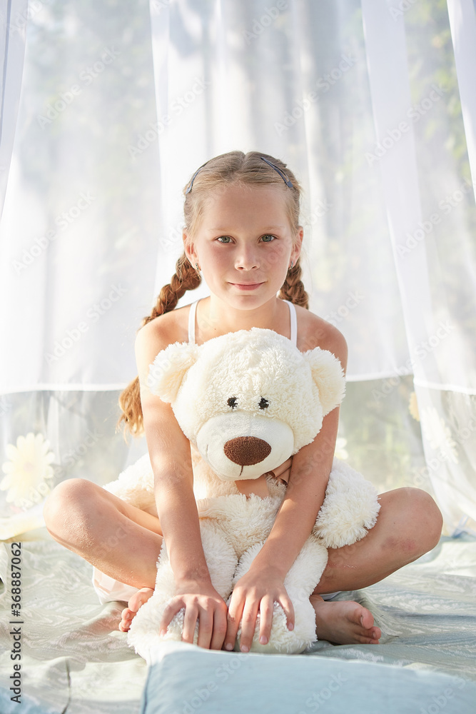Little girl in white chiffon tent with toy Little girl in white chiffon tent with toy