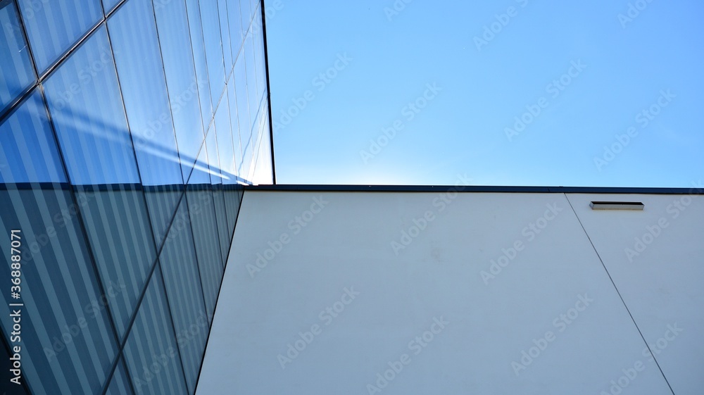 Abstract image of looking up at modern glass and concrete building. Architectural exterior detail of office building. Industrial art and detail. Abstract image of looking up at modern glass and concrete building. Architectural exterior detail of office building. Industrial art and detail.