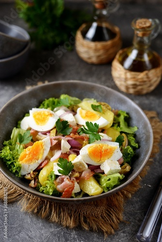 Salad with potatoes, bacon, olives, feta cheese, egg and lettuce.