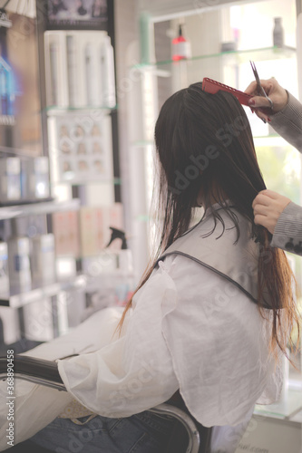 Women's haircut. Woman hairdresser making hairstyle in beauty salon. Professional stylist cutting woman's hair in salon.