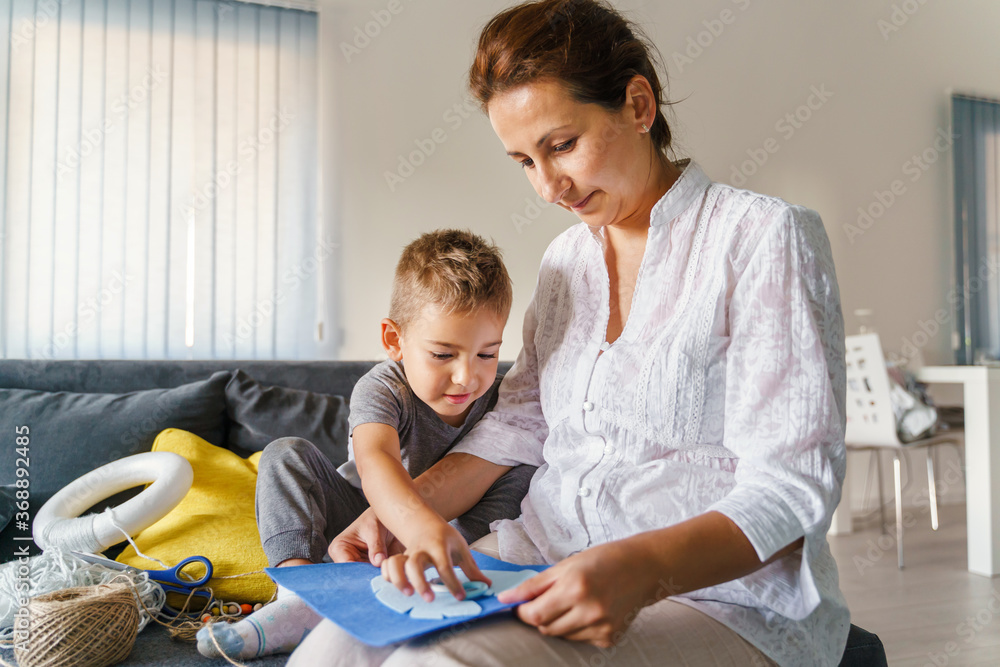 Caucasian woman playing with her son at home - Little boy learning new skills with his mother - Woman and boy learn development games making art craft on the sofa at home - Childhood bonding concept Caucasian woman playing with her son at home - Little boy learning new skills with his mother - Woman and boy learn development games making art craft on the sofa at home - Childhood bonding concept