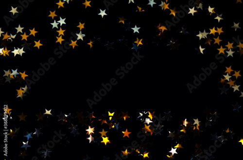 Golden stars confetti frame on black background with copy space, Festive, hol...