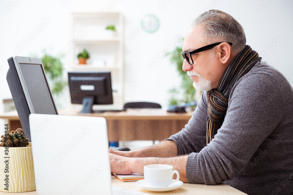 Old male employee working from house during pandemic Old male employee working from house during pandemic