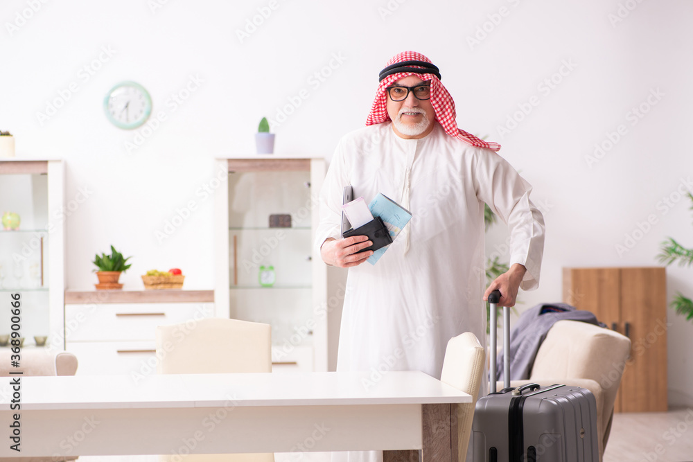 Old arab businessman preparing for business trip - obrazy, fototapety, plakaty 