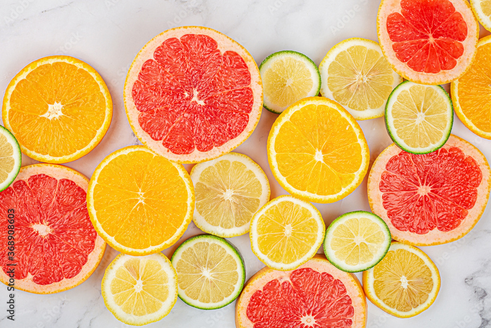 Creative background made of summer tropical fruits with grapefruit, orange, tangerine, lemon, lime on white marble background. Food concept. Flat lay, top view, copy space, mockup Creative background made of summer tropical fruits with grapefruit, orange, tangerine, lemon, lime on white marble background. Food concept. Flat lay, top view, copy space, mockup