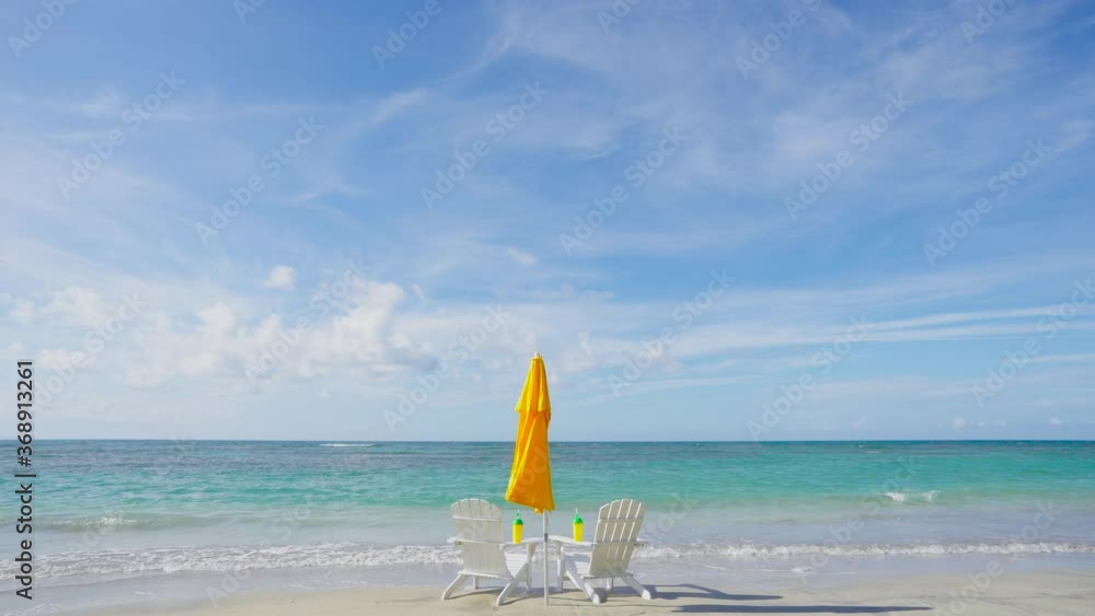 Honeymoon on the Bahamas island beach. Beach chairs and sun umbrella in the sea waves. Honeymoon on the Bahamas island beach. Beach chairs and sun umbrella in the sea waves.