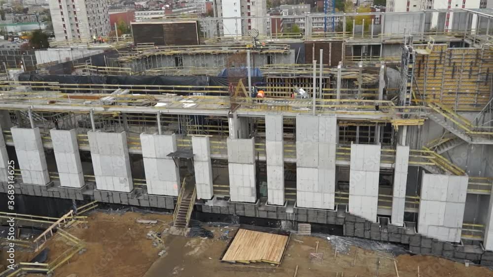 Aerial View over Construction Site In the middle of a the city. cranes and heavy machinery. excavatores. Trucks Aerial View over Construction Site In the middle of a the city. cranes and heavy machinery. excavatores. Trucks