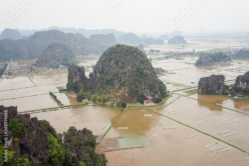 Aerial view of Ninh Binh karst mountains with a house surrounded by flooded rice fields photo