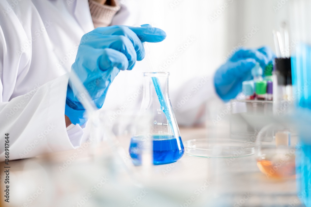 Medical scientists released a sample pipetted into a test flask to analyze the virus in a chemical laboratory. Scientific research concepts Medical scientists released a sample pipetted into a test flask to analyze the virus in a chemical laboratory. Scientific research concepts