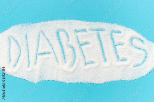 Word diabetes laid out from sugar isolated on a blue background