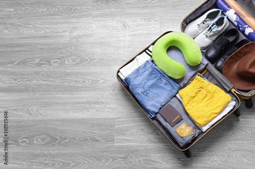 Open packed suitcase on woo...