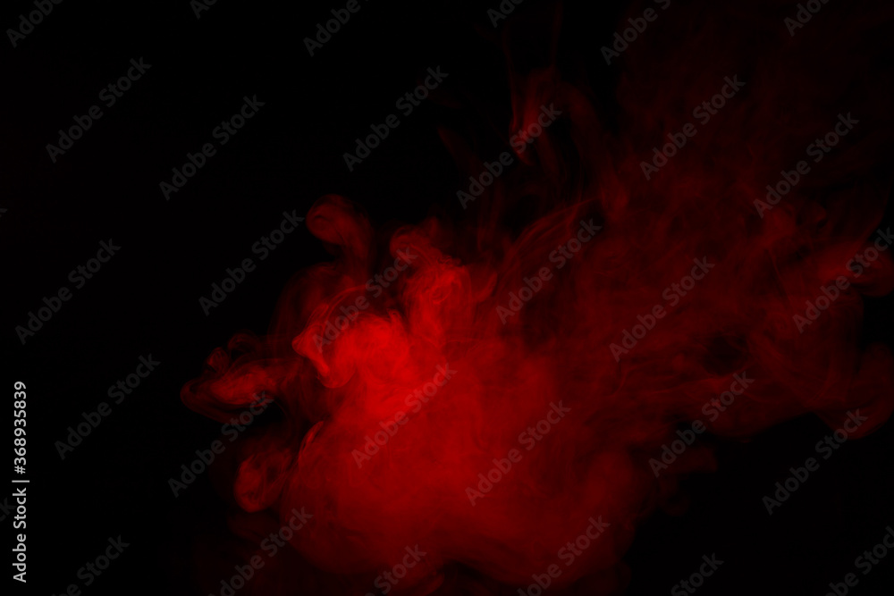 Colorful smoke close-up on a black background. Red cloud of smoke. Colorful smoke close-up on a black background. Red cloud of smoke.