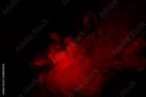 Colorful smoke close-up on a black background. Red cloud of smoke. © vfhnb12