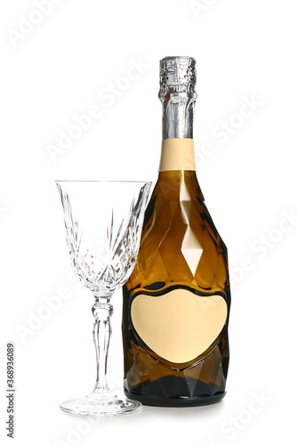 Bottle of champagne and glass on white background