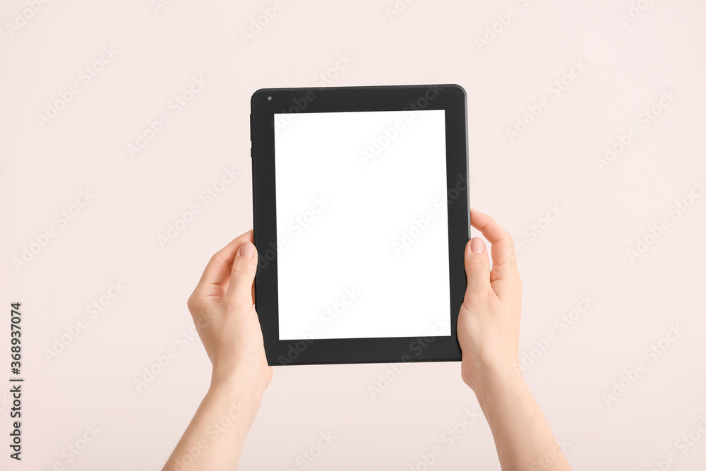 Hands with modern tablet computer on light background