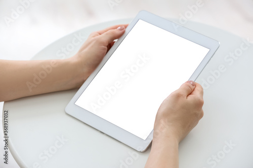 Woman with modern tablet computer at home