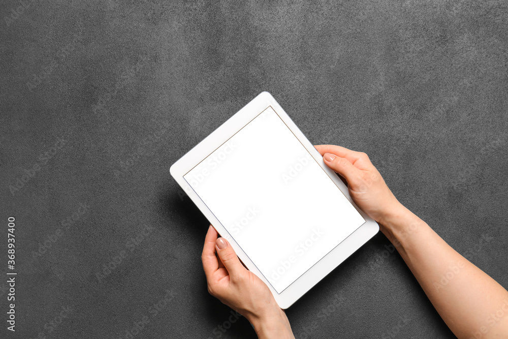Hands with modern tablet computer on dark background Hands with modern tablet computer on dark background