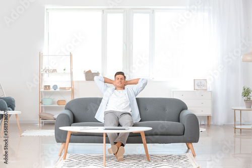 Young man relaxing on sofa ...