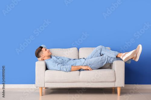 Young man relaxing on sofa ...