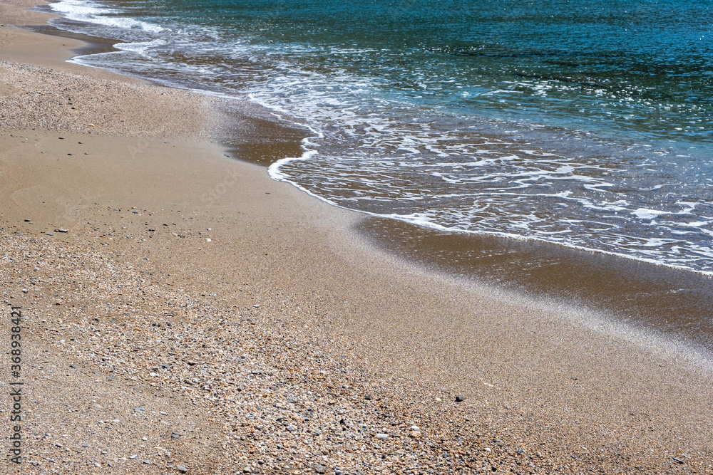 Sandy beach, ripples rolling on the coast, calm sea water background Sandy beach, ripples rolling on the coast, calm sea water background
