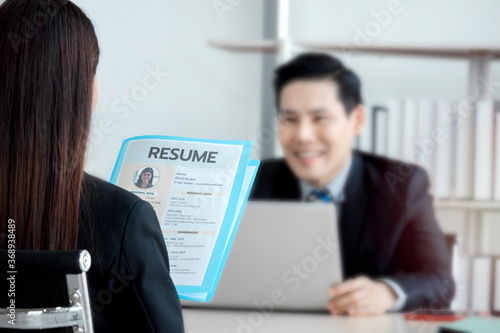 Job interview concept, woman holding her resume paper for giving to businessman manager, candidate giving CV to human resources officer