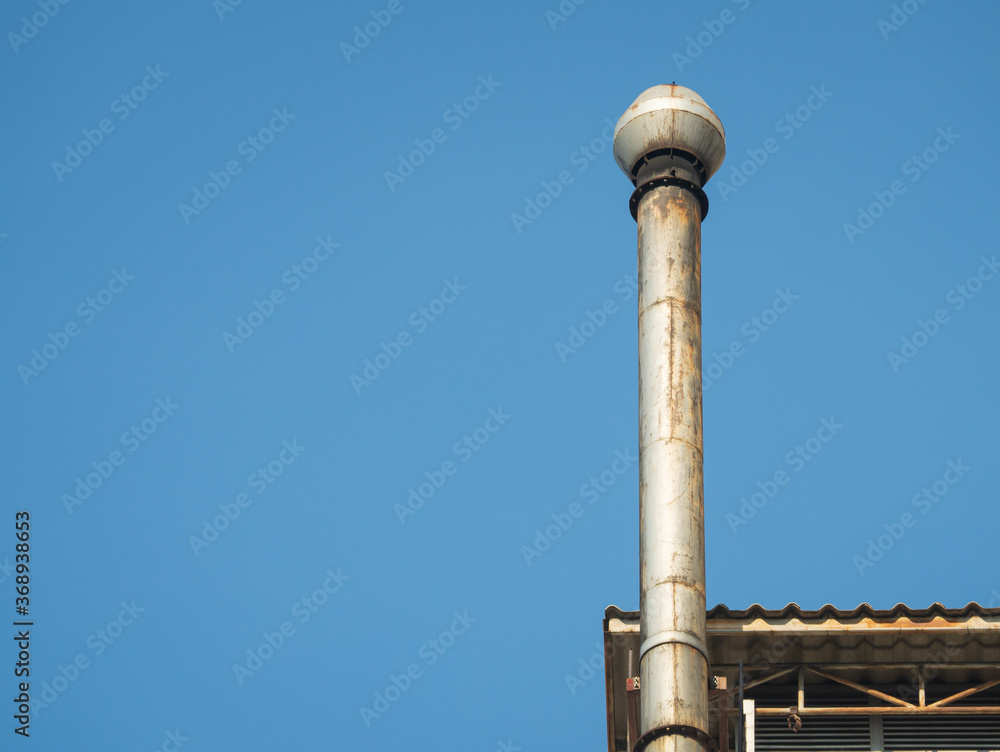 Old chimneys on the roof against the blue sky. Smokestack for smoke out from Industrial building. With space for place your text. Old chimneys on the roof against the blue sky. Smokestack for smoke out from Industrial building. With space for place your text.