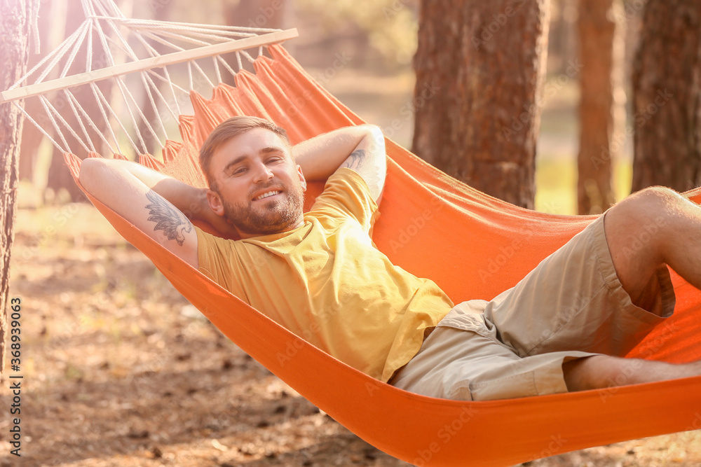 Young man relaxing in hammock outdoors Young man relaxing in hammock outdoors