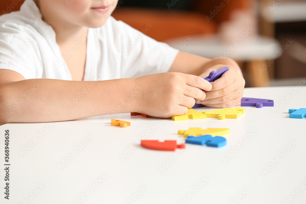 Little boy with autistic disorder doing puzzle at home Little boy with autistic disorder doing puzzle at home