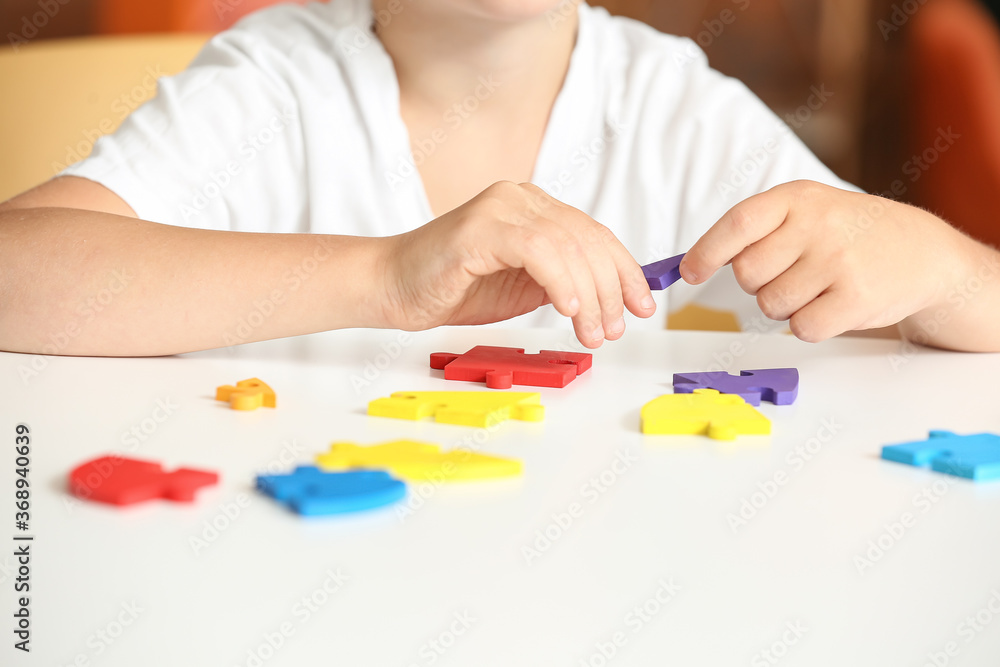 Little boy with autistic disorder doing puzzle at home Little boy with autistic disorder doing puzzle at home