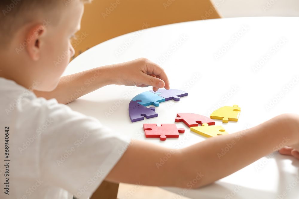 Little boy with autistic disorder doing puzzle at home Little boy with autistic disorder doing puzzle at home