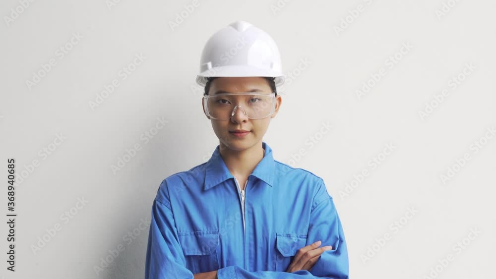 B-roll of The female technician working in the factory is standing, crossing her arms and smiling happily in his factory. Businesswoman engineering working in a factory with a lathe. Woman Working. B-roll of The female technician working in the factory is standing, crossing her arms and smiling happily in his factory. Businesswoman engineering working in a factory with a lathe. Woman Working.