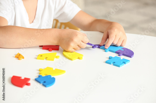 Little boy with autistic disorder doing puzzle at home