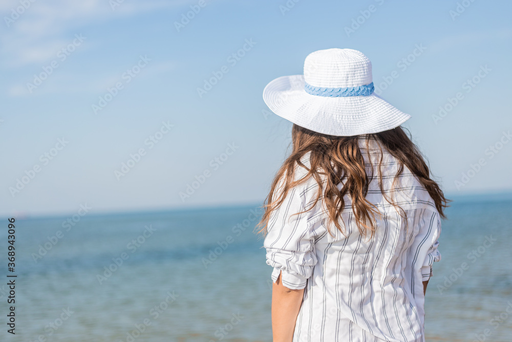 young woman in hat on beach