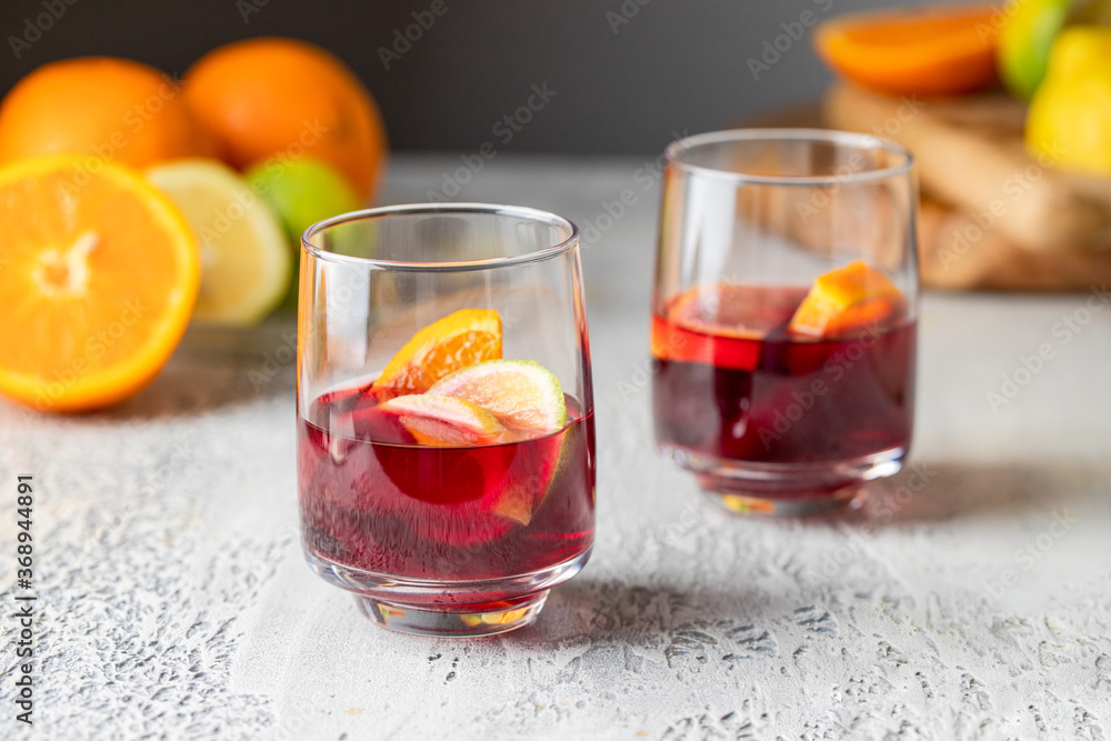 Two glasses with Refreshment acholic drink sangria making with red wine, orange and other fruit. Famous Spanish summer beverage Two glasses with Refreshment acholic drink sangria making with red wine, orange and other fruit. Famous Spanish summer beverage