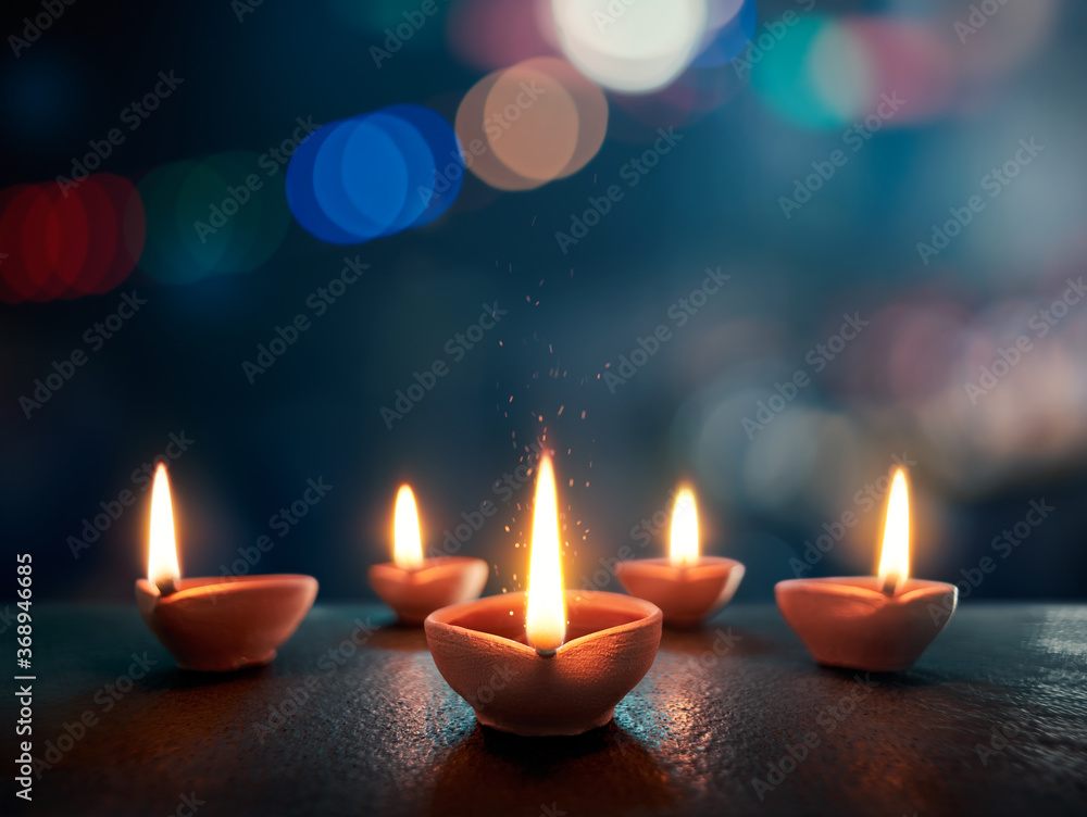Happy Diwali, Lit diya lamp on an abstract background with shallow depth of field Happy Diwali, Lit diya lamp on an abstract background with shallow depth of field