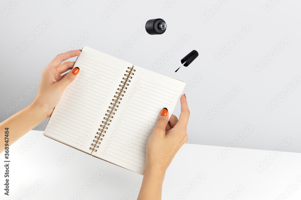 Creative composition with woman's hands and flying nail varnish Creative composition with woman's hands and flying nail varnish