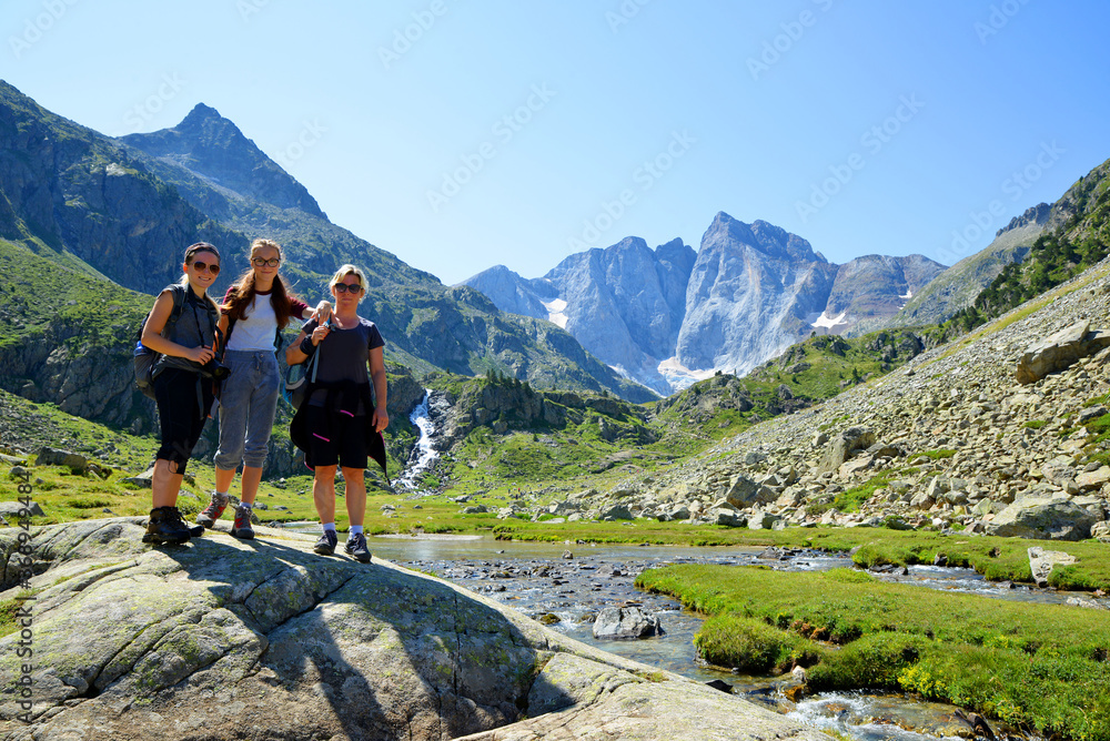 Tourists on a trip in a mountain landscape, Vignemale massif in the background. Pyrenees national park, France.
