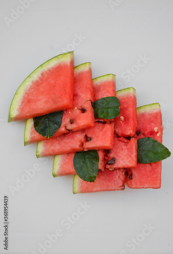 Fresh watermelon sliced into pieces on white background