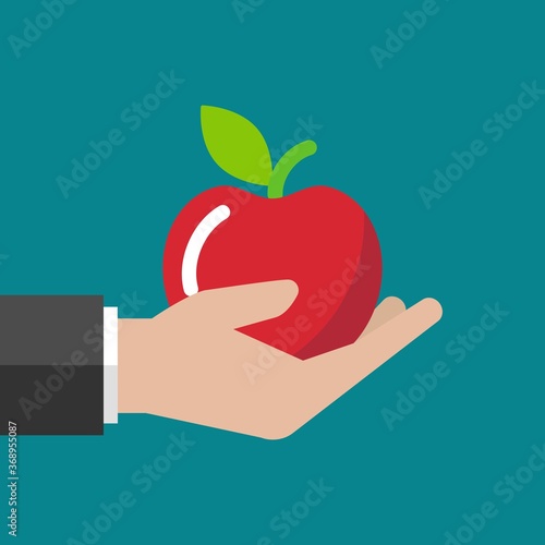 Hand holding red ripe apple. Fresh fruit in handful on blue background.