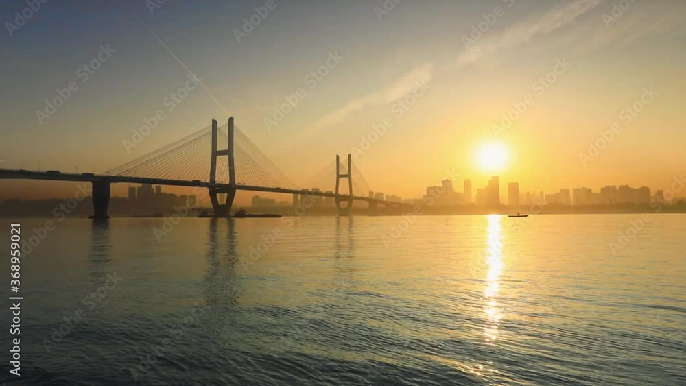 China’s Jingyue Bridge and Yangtze River at sunrise, cable-stayed bridges, sunlight reflected on water China’s Jingyue Bridge and Yangtze River at sunrise, cable-stayed bridges, sunlight reflected on water
