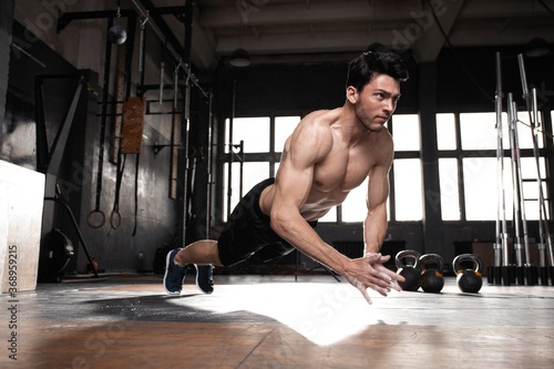 A muscular man doing a pushups at the crossfit gym