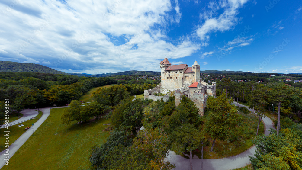 Liechtenstein Castle from the sky during sunset. The Liechtenstein Castle, situated on the southern edge of the Vienna Woods, Austria. Breathaking view about a medieval castle.