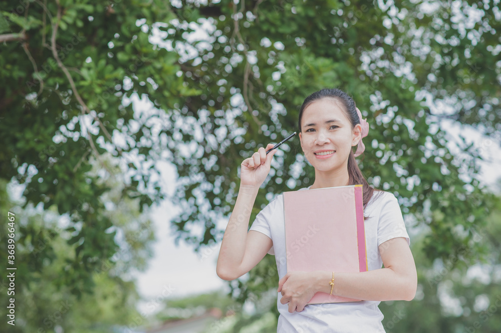 Asian women holding book standing outdoor concept,Back to school Asian women holding book standing outdoor concept,Back to school